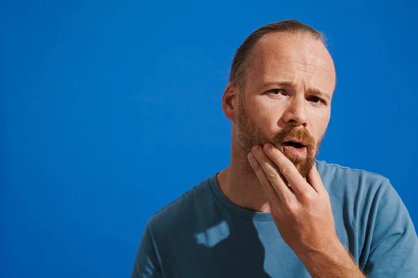 Ginger Puzzled Man Holding His Chin While Looking Camera Isolated — Fotografia de Stock