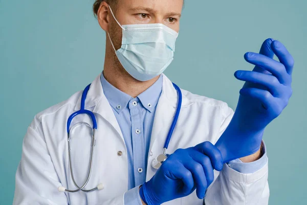 White Male Doctor Face Mask Wearing Medical Gloves Isolated Blue — 图库照片