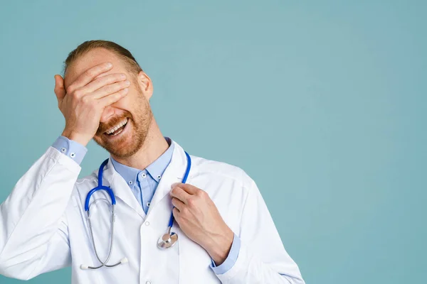 White Male Doctor Wearing Lab Coat Covering His Eyes Laughing — Stock fotografie