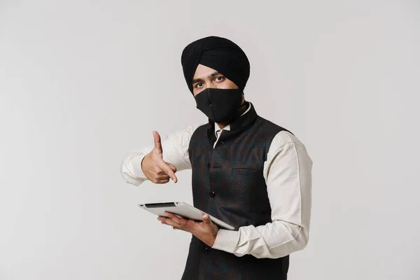 South Asian Man Wearing Face Mask Pointing Finger Tablet Computer — ストック写真
