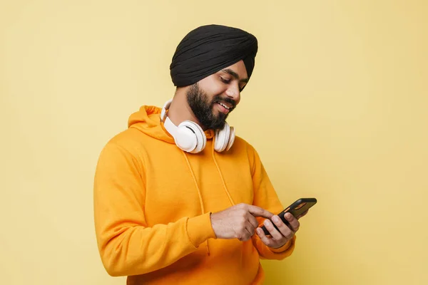 Bearded South Asian Man Wearing Turban Using Cellphone Isolated Yellow — ストック写真