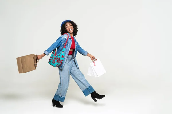 Young Black Woman Laughing While Walking Shopping Bags Isolated White — Stockfoto