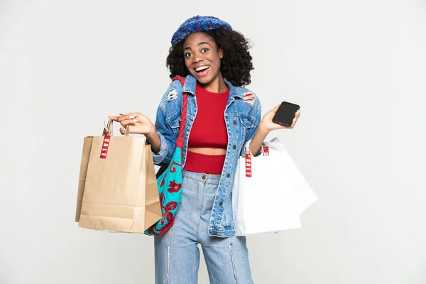 Black Woman Using Cellphone While Posing Shopping Bags Isolated White — Stock Fotó