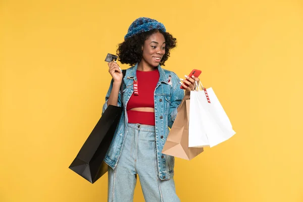 Black Woman Using Cellphone While Posing Credit Card Shopping Bags — Stock fotografie