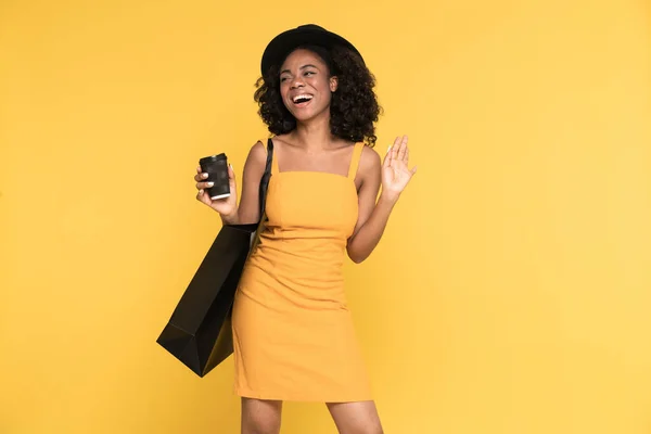 Black Woman Drinking Coffee While Posing Shopping Bag Isolated Yellow — Stockfoto