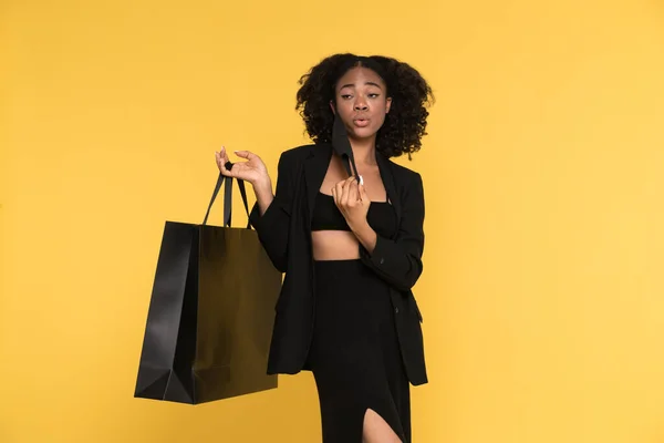 Black Young Woman Posing Shopping Bag Face Mask Isolated Yellow — Fotografia de Stock