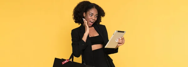 Black Excited Woman Using Tablet Computer While Posing Shopping Bag — Foto de Stock