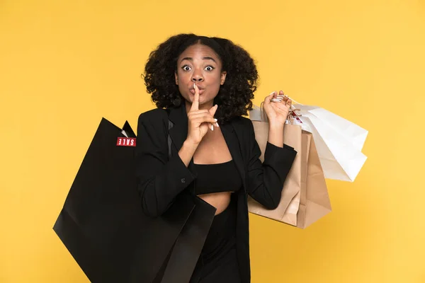 Black Woman Showing Silence Gesture While Posing Shopping Bags Isolated — Stockfoto