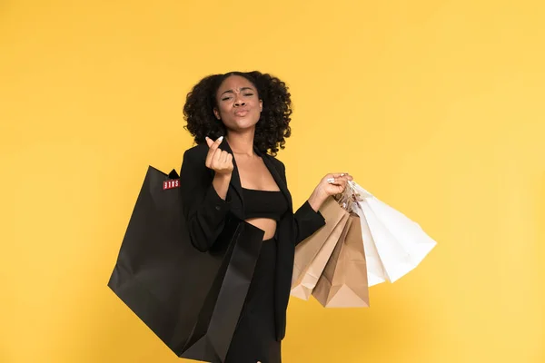 Black Young Woman Rubbing Her Fingers While Posing Shopping Bags — Stockfoto
