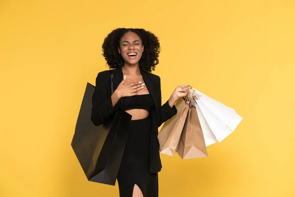 Młoda Czarna Kobieta Śmieje Się Podczas Pozowania Torbami Zakupy Izolowane — Zdjęcie stockowe