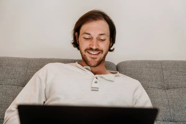European Unshaven Man Using Laptop While Resting Sofa Home — Foto Stock