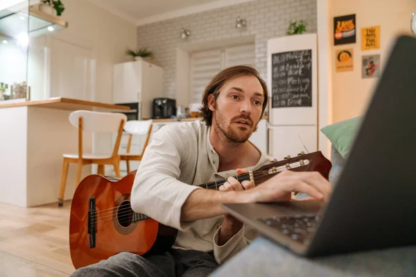 Ginger Man Playing Guitar Using Laptop While Sitting Floor Home — Foto Stock