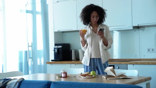 Positive Curly Haired Woman Eyeglasses Drinking Orange Juice Looking Phone — Wideo stockowe