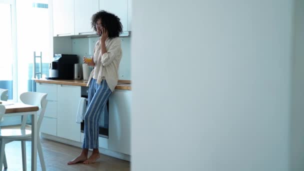 Cheerful Curly Haired Woman Eyeglasses Talking Phone Drinking Orange Juice — Stockvideo