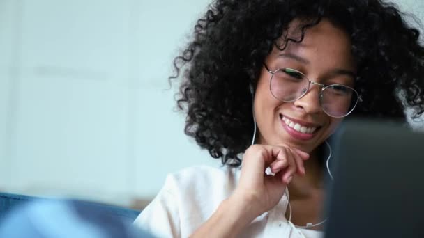 Laughing Curly Haired Woman Working Laptop Headphones While Sitting Sofa — Stockvideo