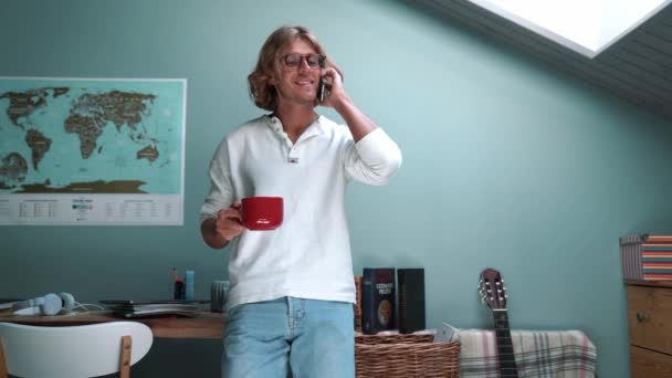 Smiling Blond Man Wearing Eyeglasses Talking Phone Cup Coffee Hands — стоковое видео