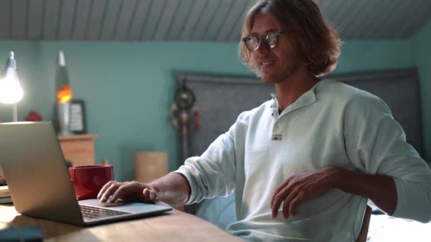 Positive Blond Man Wearing Eyeglasses Working Laptop Drinking Coffee Home — Vídeo de Stock