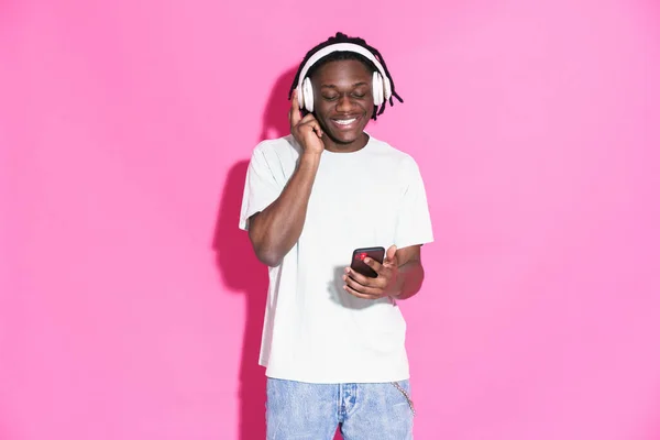 Young Black Man Listening Music Using Mobile Phone Isolated Pink — Stockfoto