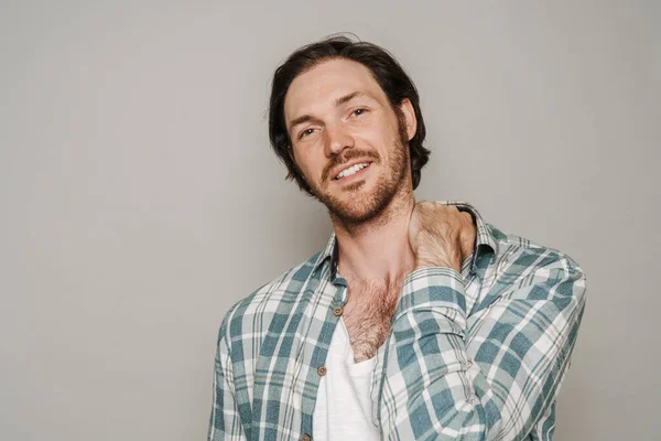 Bristle man dressed in shirt smiling while looking at camera isolated over grey background