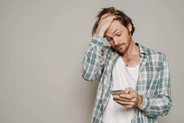 Bristle Man Holding His Head While Using Cellphone Isolated Grey — Foto de Stock