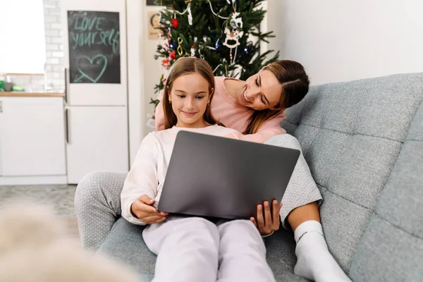 White Mother Daughter Using Laptop Together While Sitting Sofa Home — стоковое фото