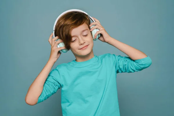 Ginger White Boy Smiling While Listening Music Headphones Isolated Blue — ストック写真