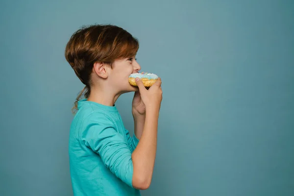 Ginger White Boy Wearing Long Sleeve Eating Doughnut Isolated Blue — Foto Stock