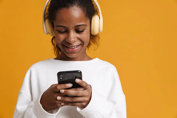 Brunette Black Girl Headphones Smiling While Using Cellphone Isolated Yellow — Stock Photo, Image