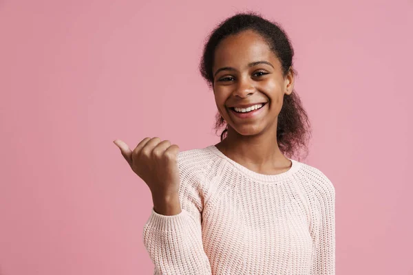 Brunette Black Girl Smiling While Pointing Finger Aside Isolated Pink — стоковое фото