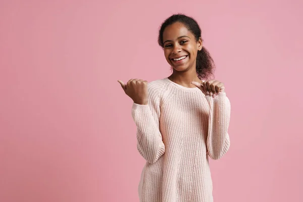 Brunette Black Girl Smiling While Pointing Fingers Aside Isolated Pink — стоковое фото