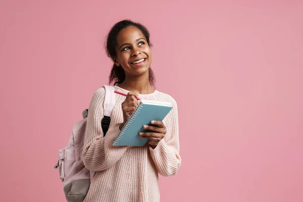 Black Girl Smiling While Writing Notes Exercise Book Isolated Pink — Stockfoto