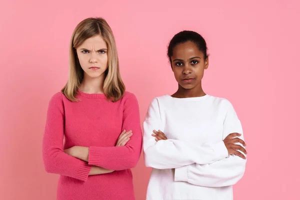 Multiracial Girls Frowning While Posing Arms Crossed Isolated Pink Wall — Stock Fotó
