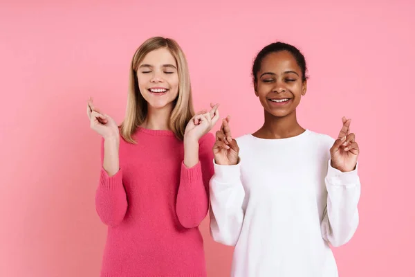 Multiracial Two Girls Wearing Sweaters Holding Fingers Crossed Isolated Pink — ストック写真