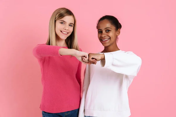 Multiracial Two Girls Wearing Sweaters Smiling Fists Bumping Isolated Pink — Stock Photo, Image