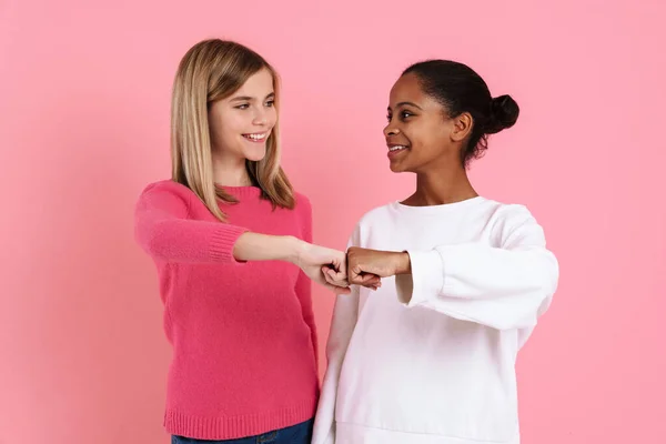 Multiracial Two Girls Wearing Sweaters Smiling Fists Bumping Isolated Pink — Foto Stock