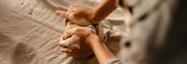 Young black ceramist woman wearing apron sculpting in clay at her workshop