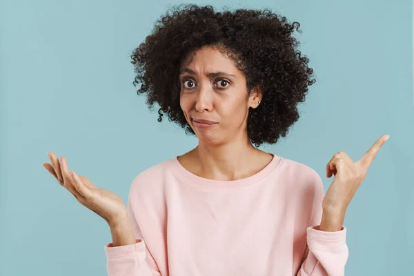 Black Perplexed Woman Pointing Finger Away While Holding Copyspace Isolated — Stockfoto