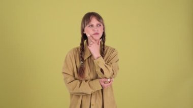 Displeased blonde woman with pigtails looking around and negatively shaking head in green studio