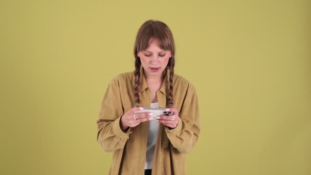 Concentrated Blonde Woman Pigtails Playing Game Phone Showing Winner Gesture — Stockvideo