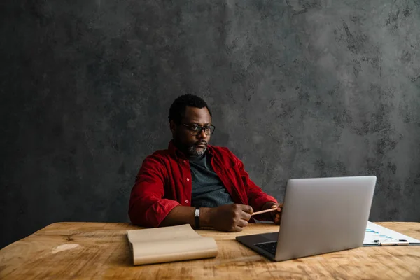 Μαύρος Άνδρας Γυαλιά Ηλίου Που Εργάζεται Φορητό Υπολογιστή Ενώ Κάθεται — Φωτογραφία Αρχείου