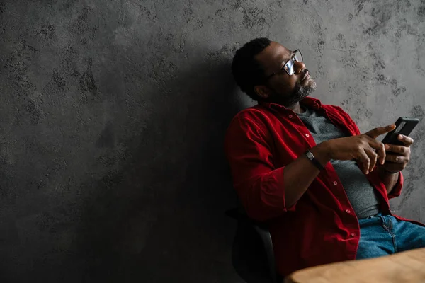 Black Man Eyeglasses Using Cellphone While Working Desk Indoors — Stock fotografie