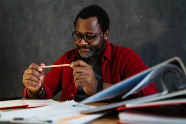 Black Man Eyeglasses Writing Notes While Sitting Desk Indoors — Stock fotografie