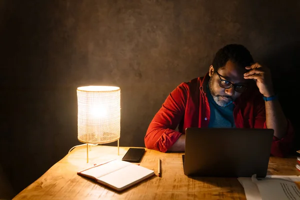 Black Puzzled Man Eyeglasses Working Laptop While Sitting Desk Indoors — Stock fotografie