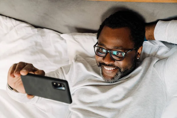 Black Man Taking Selfie Photo Mobile Phone While Resting Bed — Stockfoto