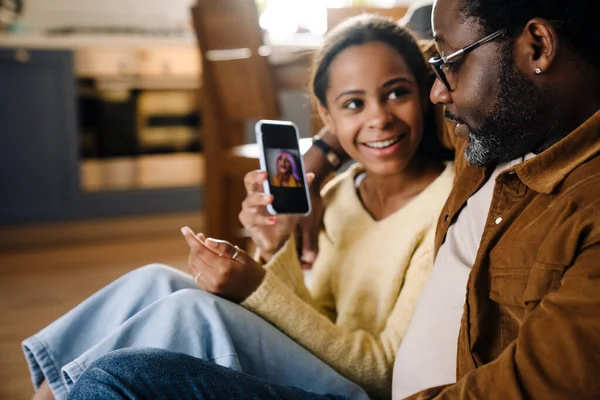 Black Girl Her Father Hugging Using Cellphone While Sitting Floor — Foto Stock