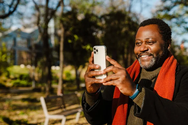 Black Bearded Man Taking Photo Cellphone While Strolling Park Outdoors — Stockfoto