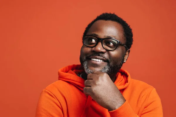 Black Bearded Man Eyeglasses Smiling Looking Aside Isolated Orange Background — ストック写真