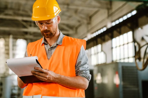 White Man Wearing Helmet Vest Writing Clipboard While Working Factory — Stok fotoğraf