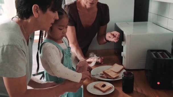 Αυτοπεποίθηση Ώριμο Λεσβιακό Ζευγάρι Κάνει Τοστ Ψωμί Υιοθετημένη Ασιατική Κόρη — Αρχείο Βίντεο