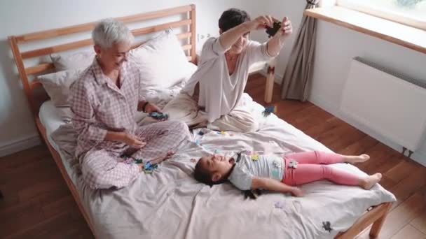 Laughing Mature Lesbian Couple Talking Playing Puzzles Adopted Asian Daughter — Stockvideo